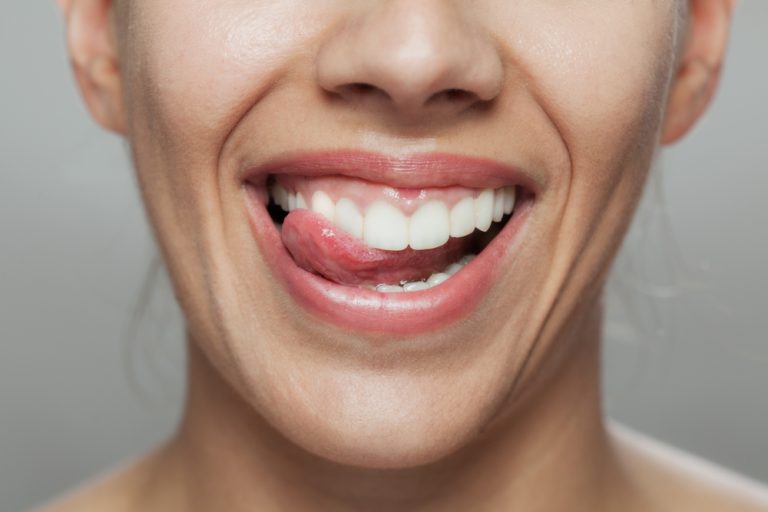 close up image of woman's mouth with tongue out