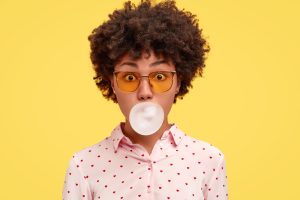 woman blowing bubble with chewing gum
