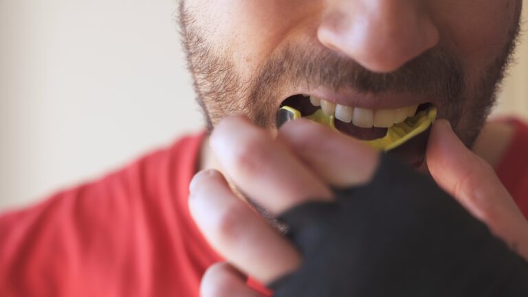man putting recreational athletic mouth guard in for sport