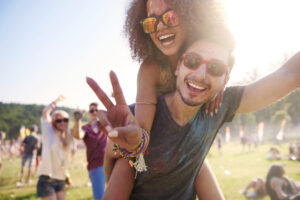 Smiling festival attendees enjoying music and outdoor event, potential dental emergency risks.
